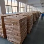 Des rangées de produits finis bien organisés, stockés sur des étagères dans un entrepôt propre et bien éclairé, prêts à être expédiés.