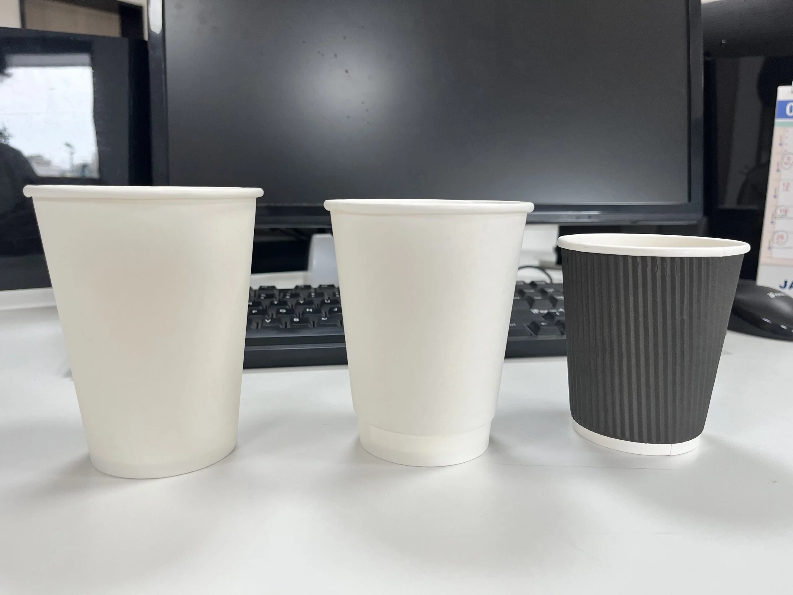 La imagen muestra los vasos de papel, que incluyen vasos de una capa, vasos huecos de doble capa y vasos ondulados de color blanco y negro.