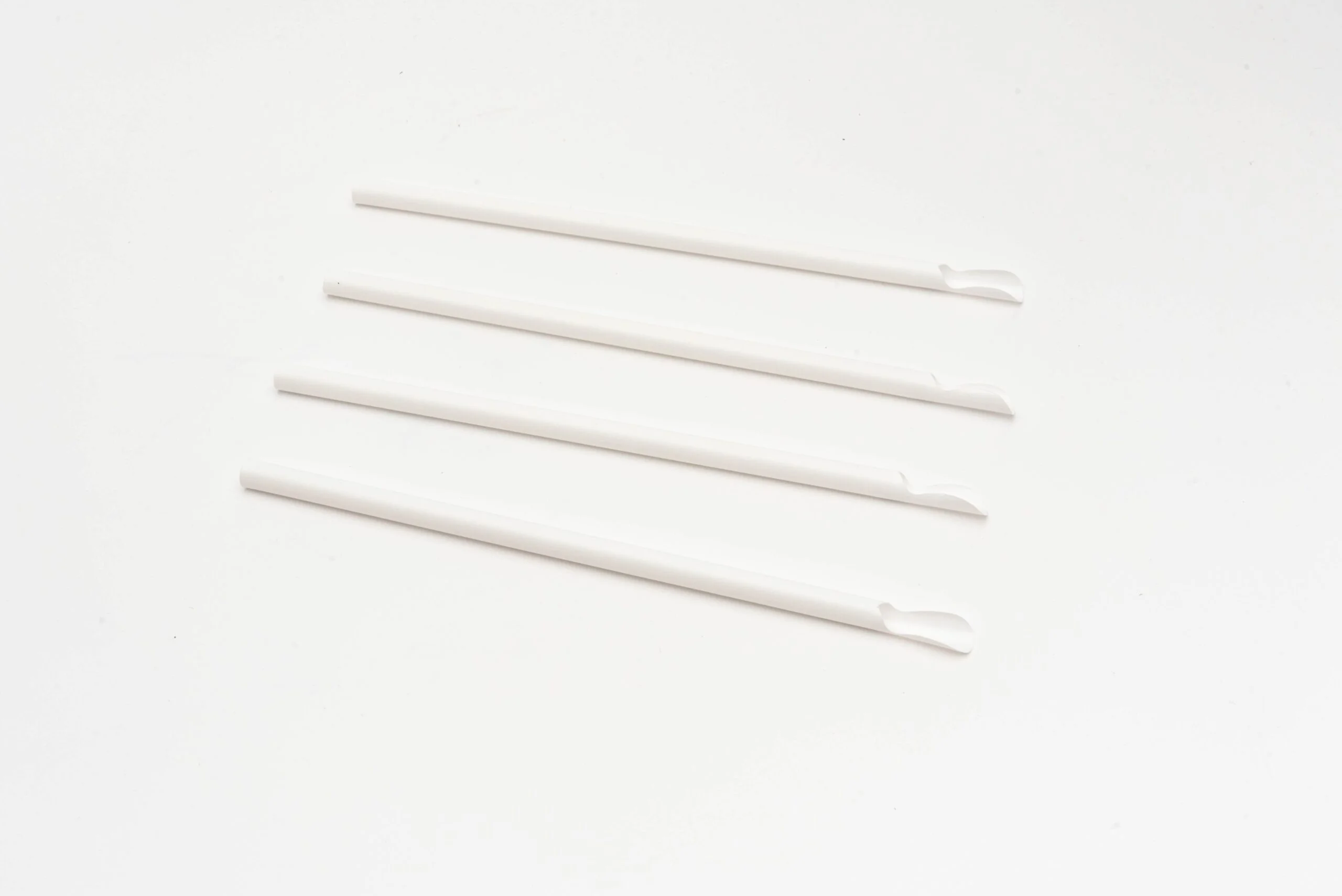 Image showing white PLA spoon straws, designed with one end flattened and shaped like a spoon for scooping up semi-solid drinks.