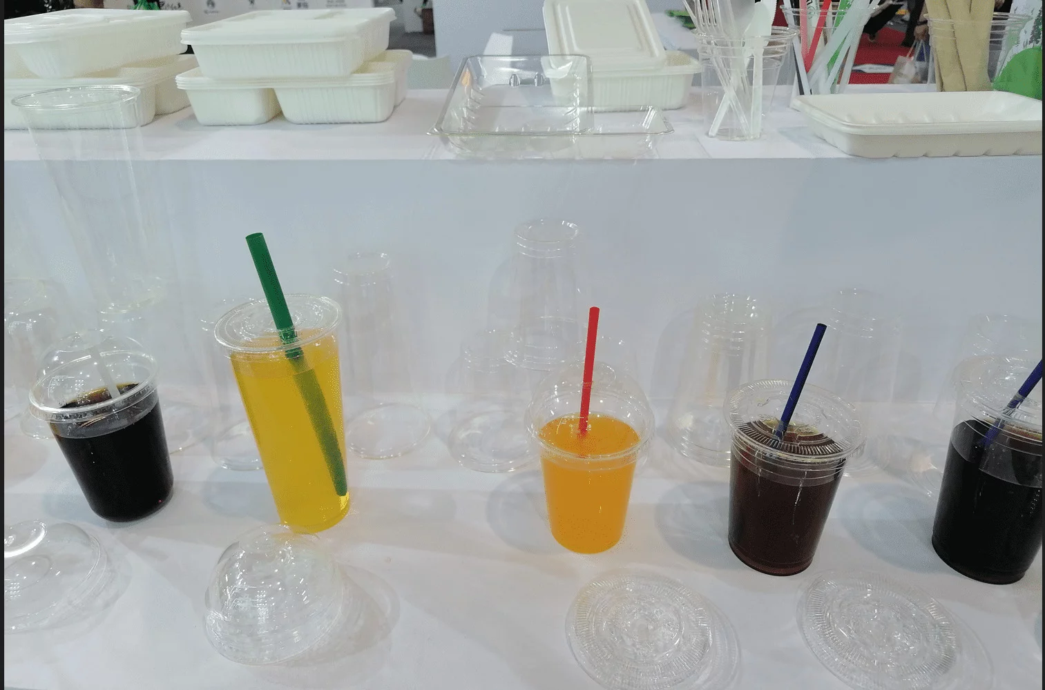 Vasos de PLA respetuosos con el medio ambiente con pajitas de PLA, vasos fríos de PLA con una selección de tapas, incluidas tapas de cúpula y dos diseños diferentes de tapa plana. Estos productos son biodegradables y ecológicos.
