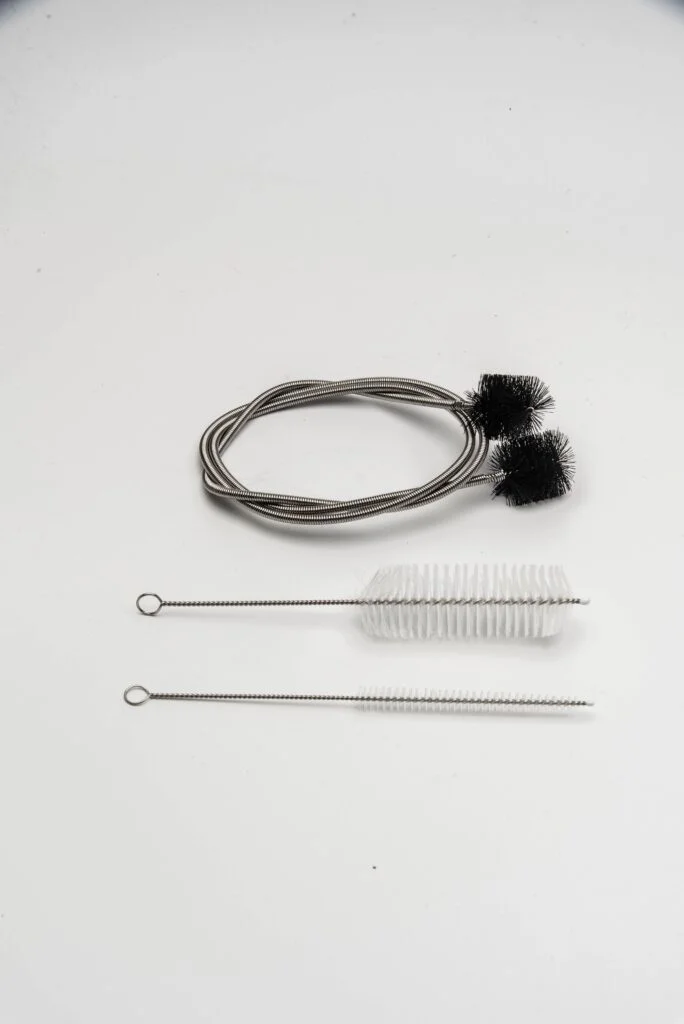 A imagem mostra o kit de limpeza de trombone, que consiste em escovas de limpeza de instrumentos musicais.